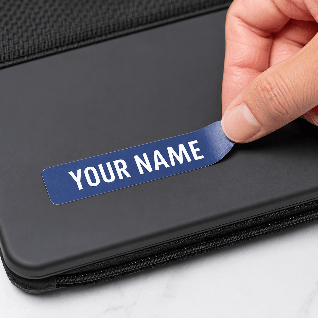 Peeling a personalized waterproof name label from a sticker sheet